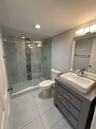 a bathroom with a sink a toilet and shower