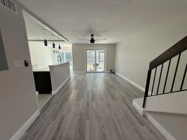 a view of a hallway with wooden floor and staircase