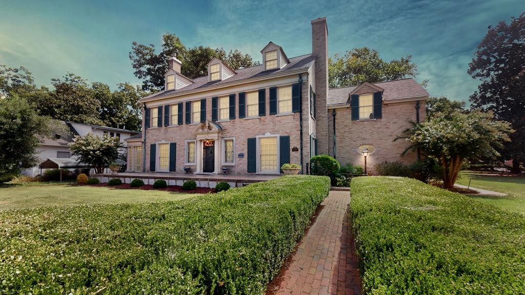 a view of a house with a yard and sitting area