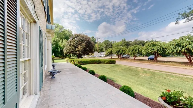 a view of a house with a yard and sitting area