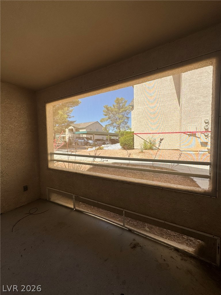 5141 South Lindell Road, Unit 102 Las Vegas, NV 89118 - Photo 17 of 17 A screened porch overlooks an adjacent building, offering a simple outdoor retreat.