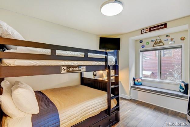 97 Kinney Way, Unit A Winter Park, CO 80482 - Photo 18 of 27 a bedroom with a bed and a large window with wooden floor