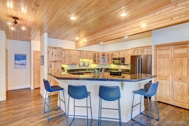 97 Kinney Way, Unit A Winter Park, CO 80482 - Photo 9 of 27 a kitchen with stainless steel appliances kitchen island granite countertop a table chairs sink and cabinets