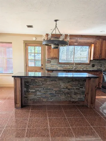 a view of kitchen with a sink a counter top space and cabinets