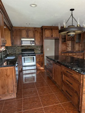 a kitchen with stainless steel appliances a stove a sink and a microwave