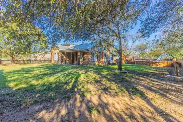 a view of a backyard with wooden fence and floor