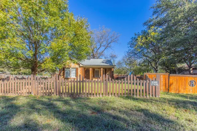 a view of house with backyard and trees