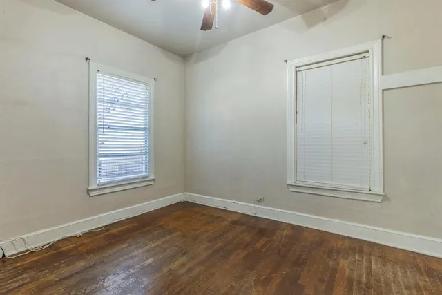 a view of an empty room with wooden floor and a flat screen tv