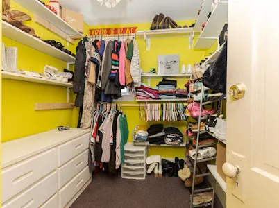 a view of walk in closet with clothes and shoes