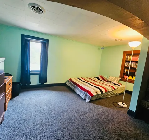 a bedroom with a bed and a window