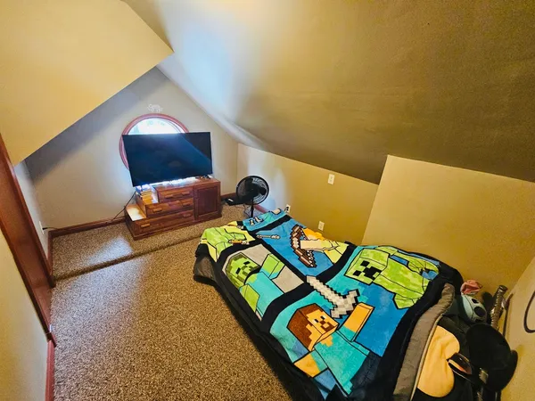 a bedroom with a bed and a painting on the wall