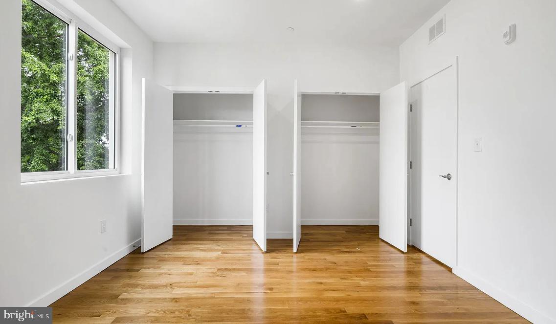 300 Budd Street, Unit D2 Philadelphia, PA 19104 - Photo 13 of 23 a view of an empty room with wooden floor and windows