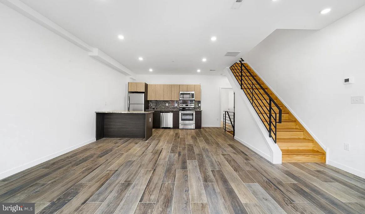 300 Budd Street, Unit D2 Philadelphia, PA 19104 - Photo 5 of 23 a view of a kitchen with wooden floor and electronic appliances