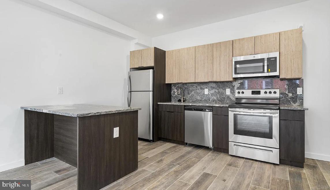 300 Budd Street, Unit D2 Philadelphia, PA 19104 - Photo 9 of 23 a kitchen with stainless steel appliances granite countertop a stove a sink and a refrigerator