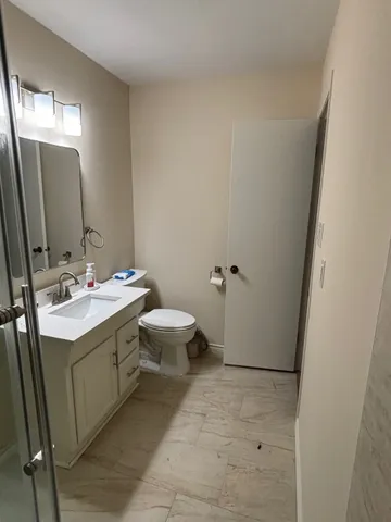 a bathroom with a sink and mirror with toilet