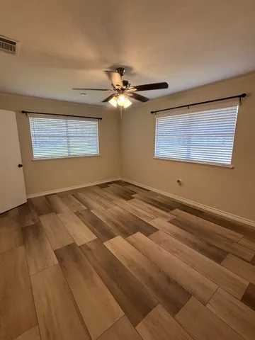 a view of a room with a ceiling fan and a window