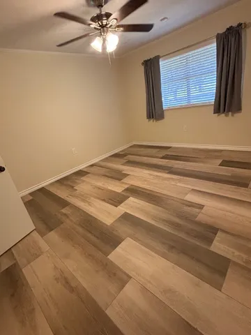 a view of a livingroom with an empty space & a ceiling fan