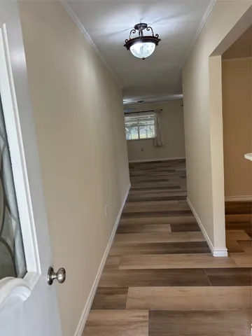 a view of a hallway with wooden floor and staircase