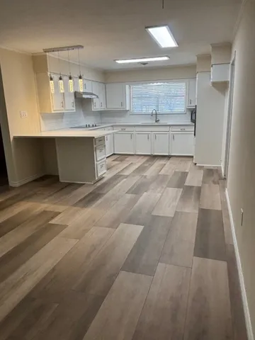a large kitchen with a sink and cabinets