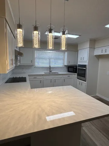 a kitchen with kitchen island a counter top and stove
