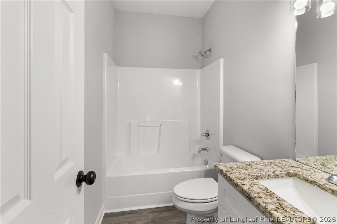 802 Holmes Street Clinton, NC 28328 - Photo 17 of 31 a bathroom with a granite countertop bathtub shower sink vanity mirror and toilet