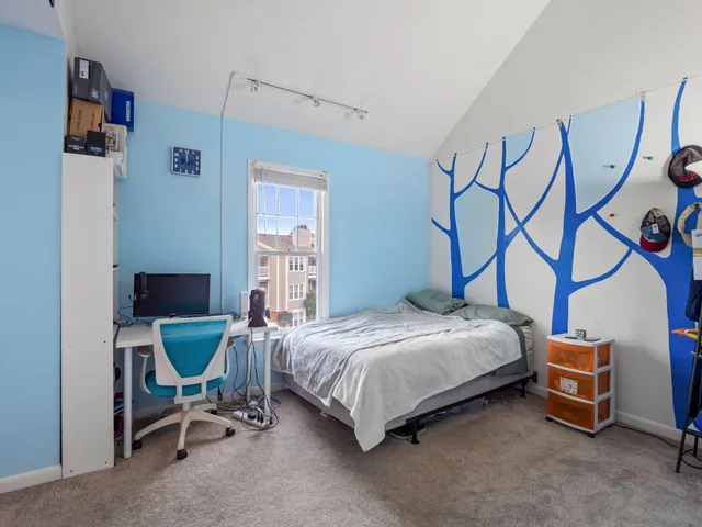a bedroom with a bed chair and a window