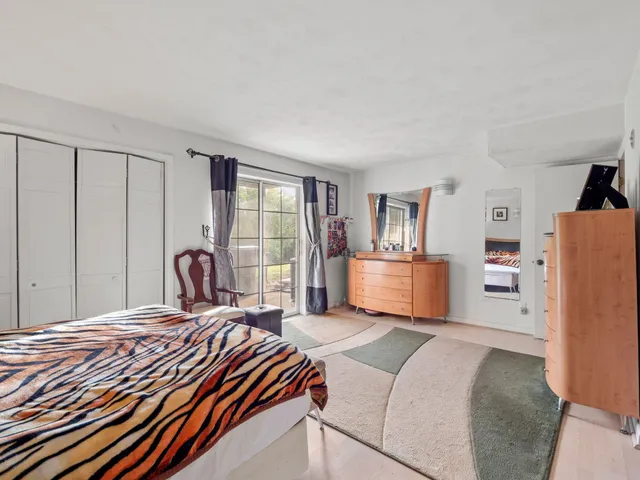 a bedroom with a bed and a large window