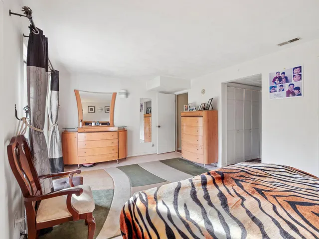 a bedroom with a bed and a refrigerator