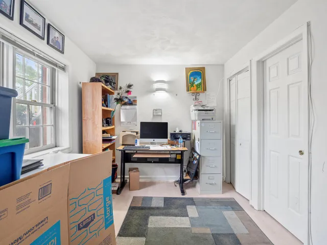 a view of a workspace with furniture and a window
