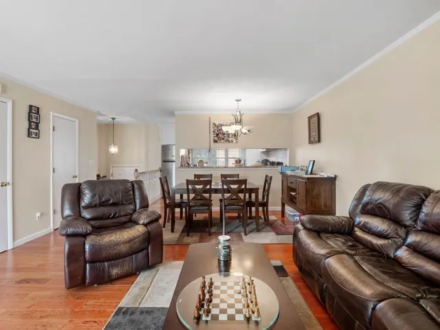 a living room with furniture a rug and a dining table