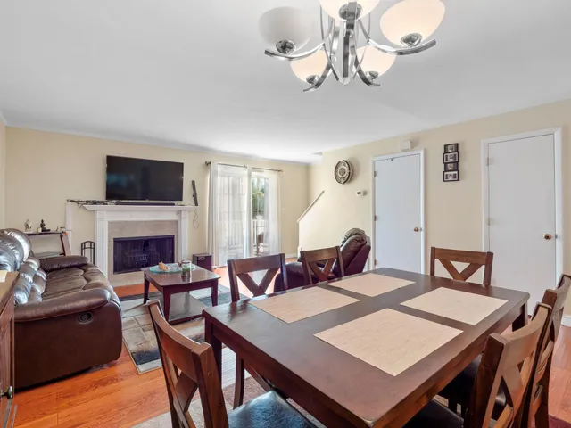 a view of a dining room with furniture a chandelier and wooden floor