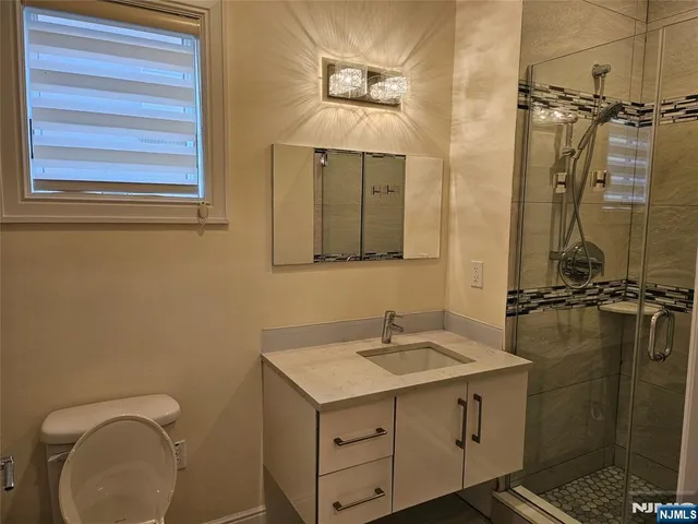 a bathroom with a sink a toilet and shower