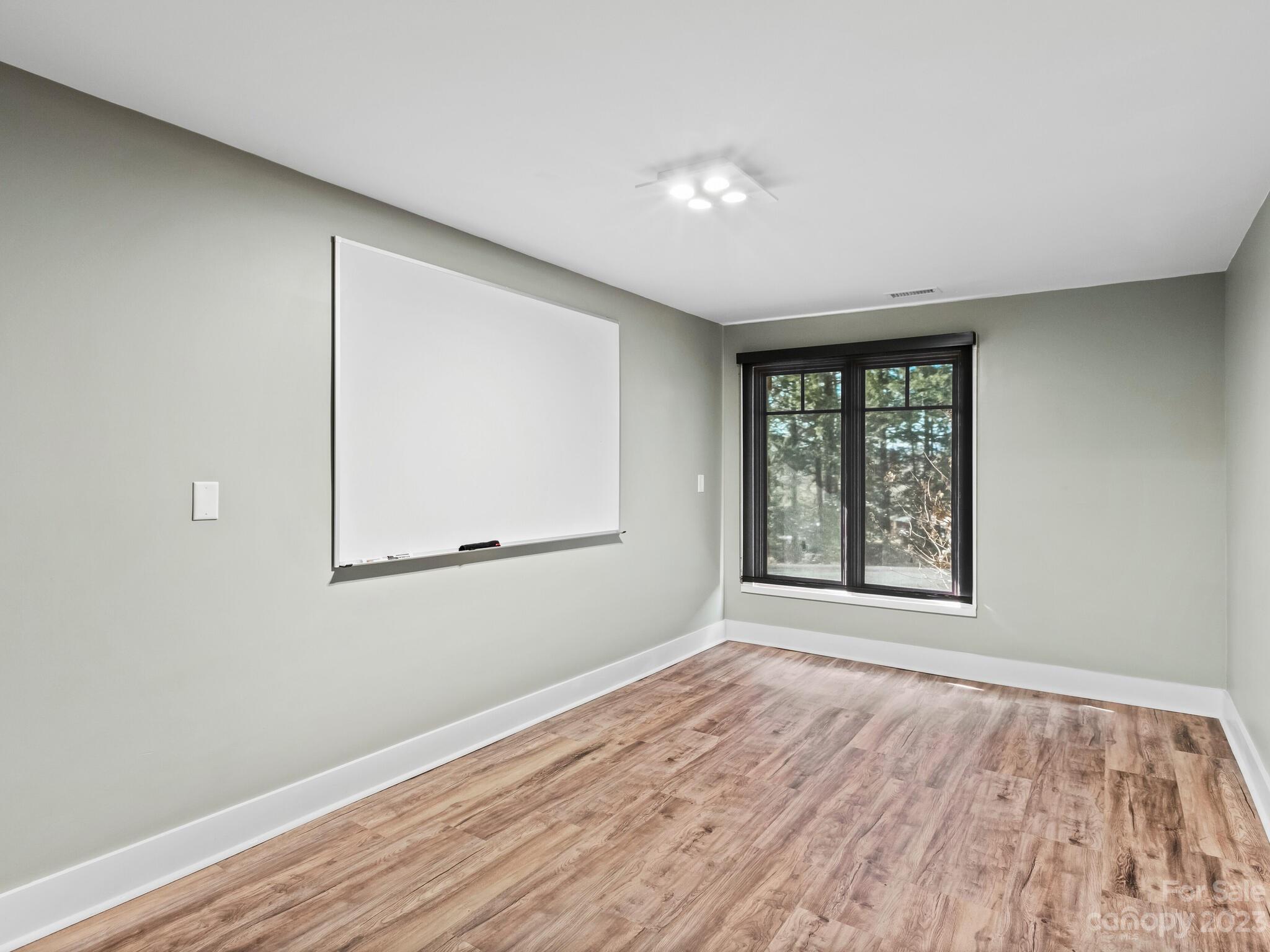 122 Emmas Grove Road Fletcher, NC 28732 - Photo 36 of 48 an empty room with wooden floor and windows