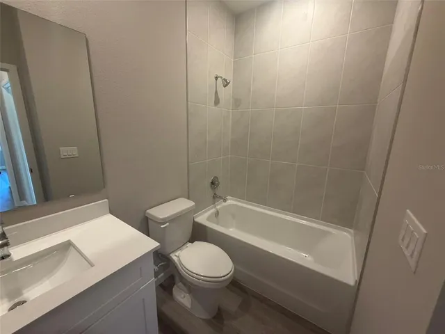 a bathroom with a sink mirror vanity and toilet