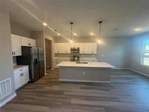 a view of kitchen with refrigerator microwave and stove
