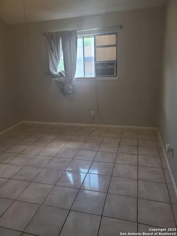 an empty room with windows and fireplace