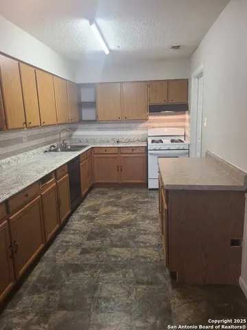 a kitchen with a sink stove and cabinets