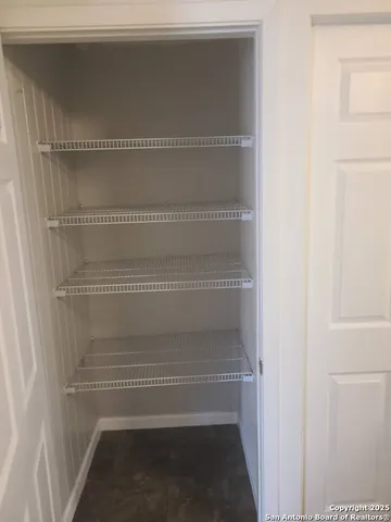 a view of walk in closet with empty racks