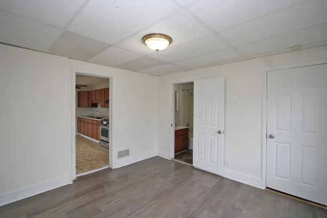 a view of empty room with wooden floor and closet