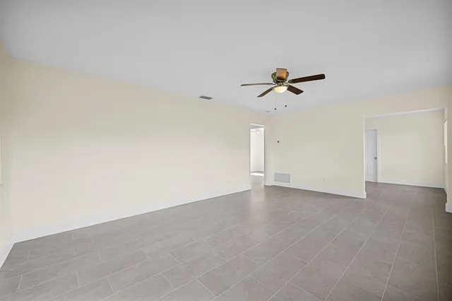 an empty room with an empty space and a ceiling fan