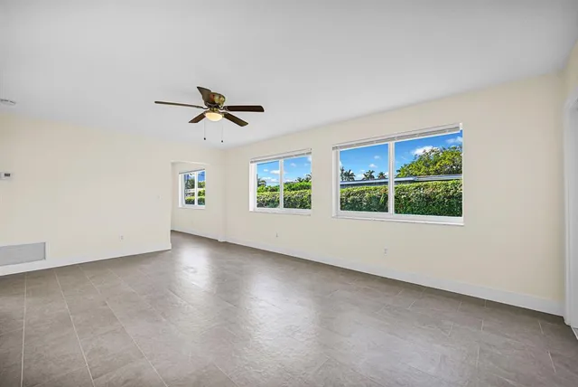 an empty room with a window and a ceiling fan