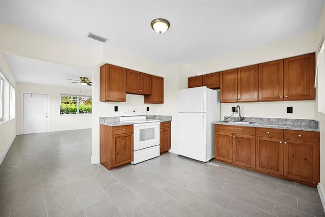 a kitchen with granite countertop a sink stainless steel appliances and cabinets