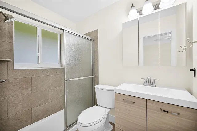 a bathroom with a sink a toilet and shower