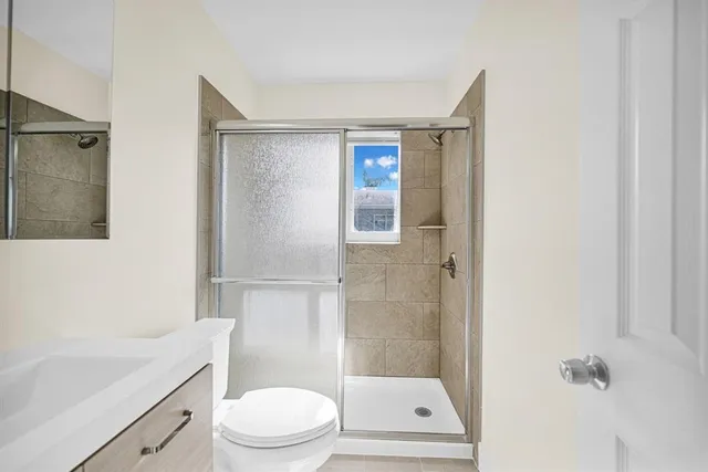 a bathroom with a shower a toilet and a sink