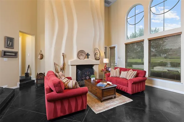 a living room with furniture fireplace and a large window