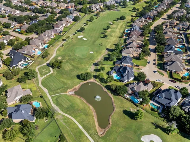 an aerial view of a residential houses with yard