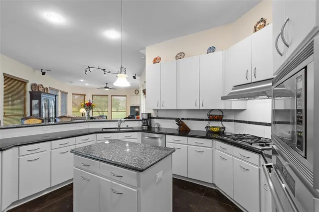 a kitchen with lot of counter top space sink stove and cabinets
