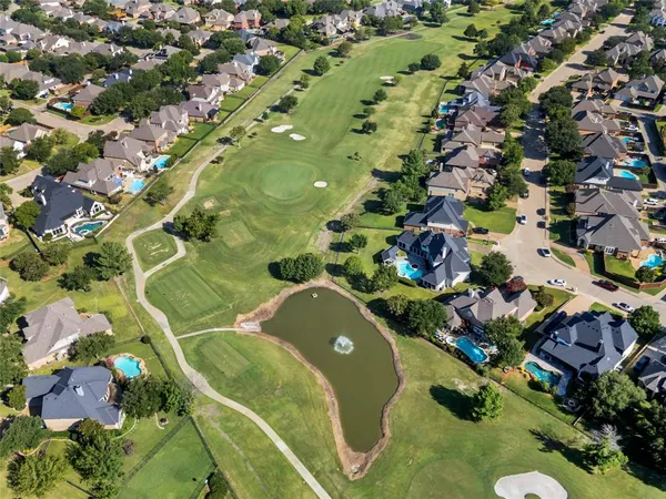 an aerial view of a residential houses with yard