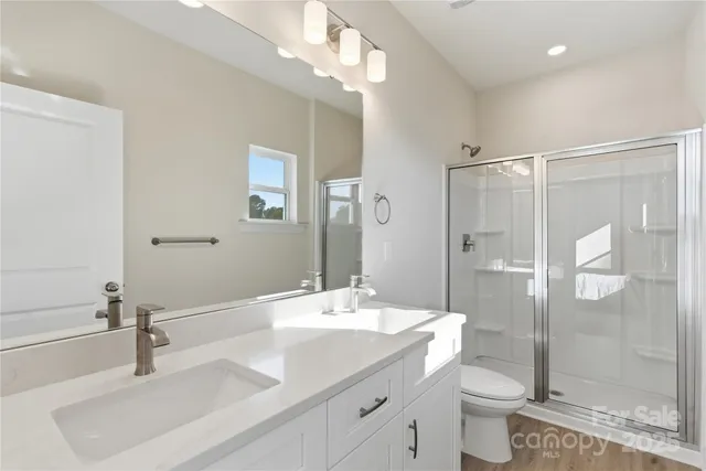 a bathroom with a double vanity sink toilet and shower