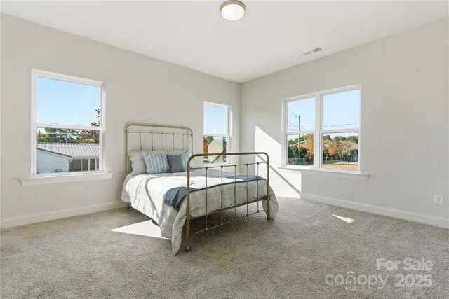 a bed sitting in a bedroom next to a window